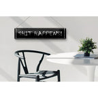 Schwarzes rechteckiges blechschild mit weißer kreideaufschrift shit happens zum aufhängen aus metall 46x10 cm