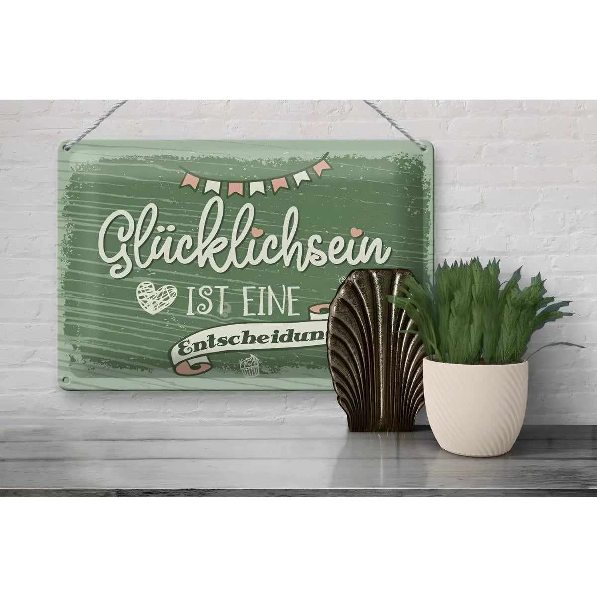 Ein rustikales grünes blechschild mit weißer kursive schrift und dekorativer girlande an weißer ziegel wand