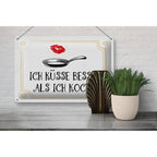 Weißes rechteckiges blechschild 30x20cm mit goldrand, pfannenskizze, lippenstiftabdruck und spruch ich küsse besser als ich koche