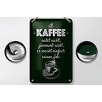 Dunkelgrünes rechteckiges blechschild aus metall mit weiß eingraviertem spruch kaffee jammert nicht und kaffeetasse