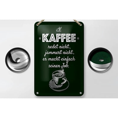 Dunkelgrünes rechteckiges blechschild aus metall mit weiß eingraviertem spruch kaffee jammert nicht und kaffeetasse