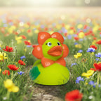 Warme grüne badeente mit orangenem blumenkopfschmuck und schleife aus gummi für spiel und badspaß