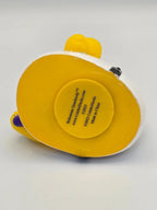 Gelbe und weiße gummiente bohemian quacksody mit rundem label auf der rückseite von celebriducks