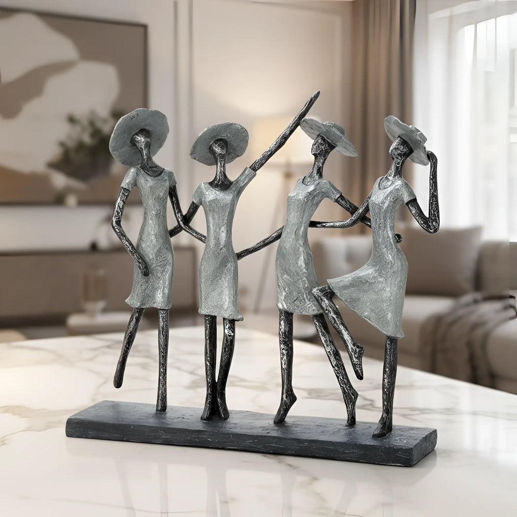 Silberne abstrakte skulptur mit vier stilisierten frauen in fliessenden kleidern und großen hüten aus kunstharz