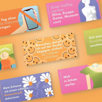 Bunte rechteckige karten mit fröhlichen smileys und deutschen texten für das kartenspiel challenge-box 30 glücks herausforderungen