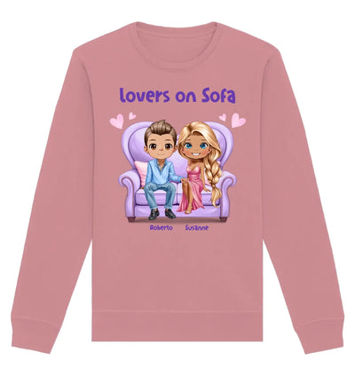 Ein weiches rosa sweatshirt mit langärmeln und cartoonmotiv zweier liebender roberto und susanne auf lila sofa