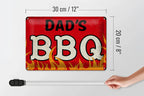 Rotes rechteckiges blechschild dad’s bbq mit abgenutzter weißer und schwarzer schrift und flammengrafik 20x30cm