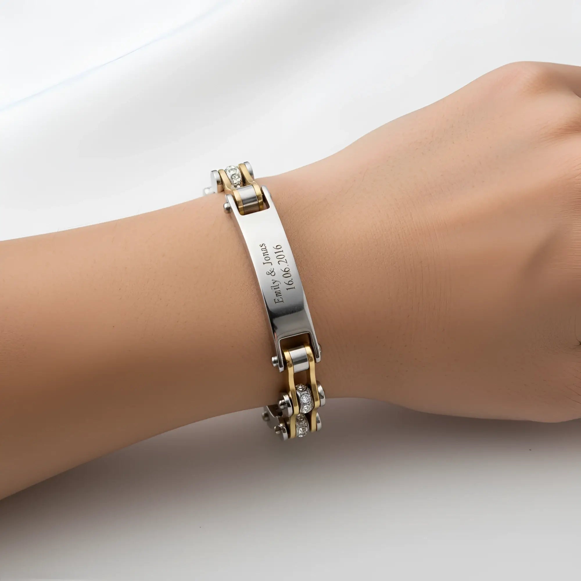 Damen armband biker-kette gold mit graviertem namensschild und diamantakzenten aus metall am handgelenk getragen