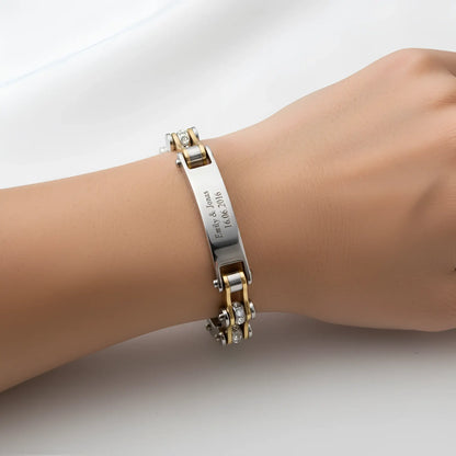 Damen armband biker-kette gold mit graviertem namensschild und diamantakzenten aus metall am handgelenk getragen