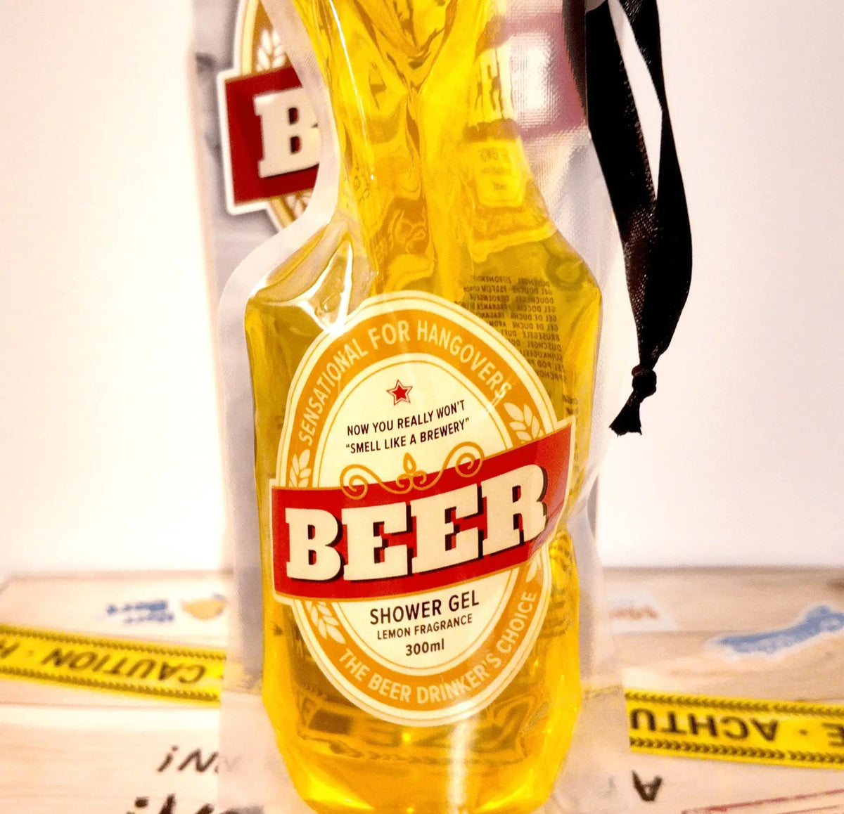 Gelbe bierförmige duschgel-flasche mit rotem weißem etikett und zitronenduft im 300 ml pet-beutel