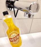 Gelbes bier-duschgel mit zitronenduft in einem squeezable PET-beutel mit schwarzem Verschluss und rot-weißem Etikett