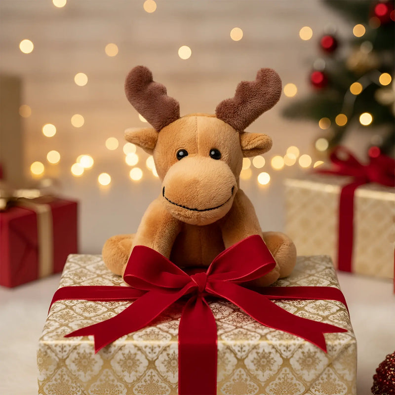 A plüschiges braunes elch emil stofftier mit weichem fell und bestickten augen auf weihnachtsgeschenkpapier