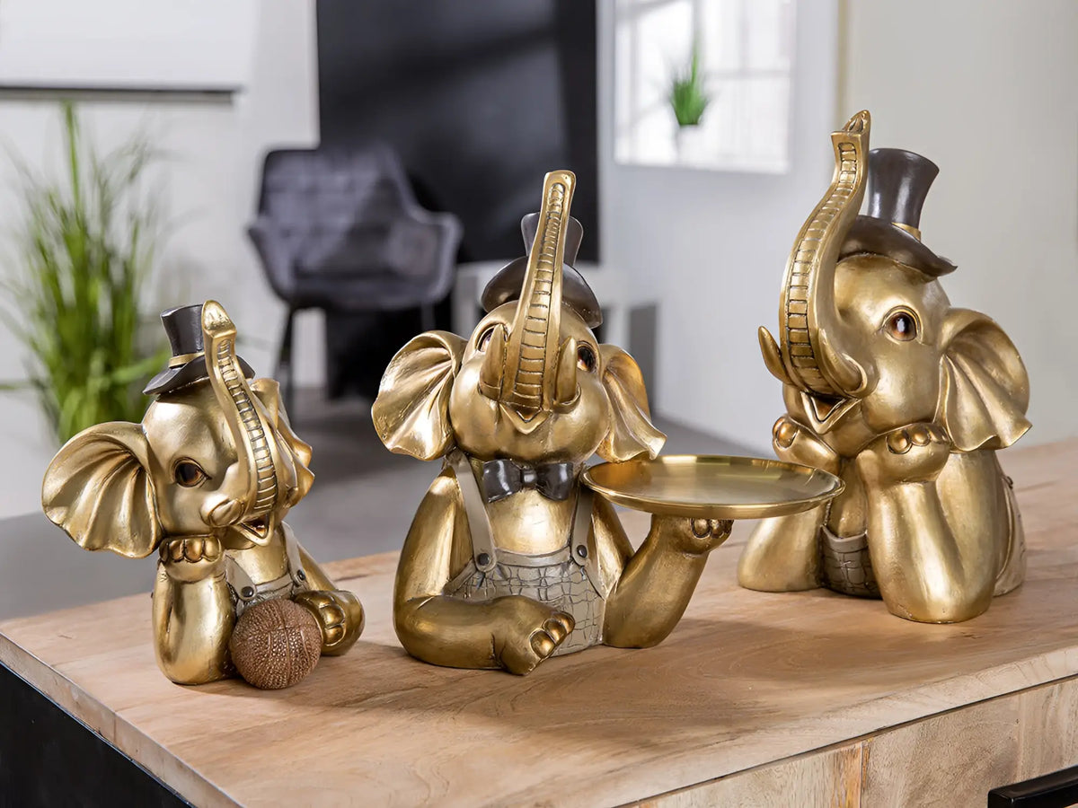 Drei goldfarbene elefantenfiguren aus kunstharz mit formeller kleidung und zylinder von gilde maroni