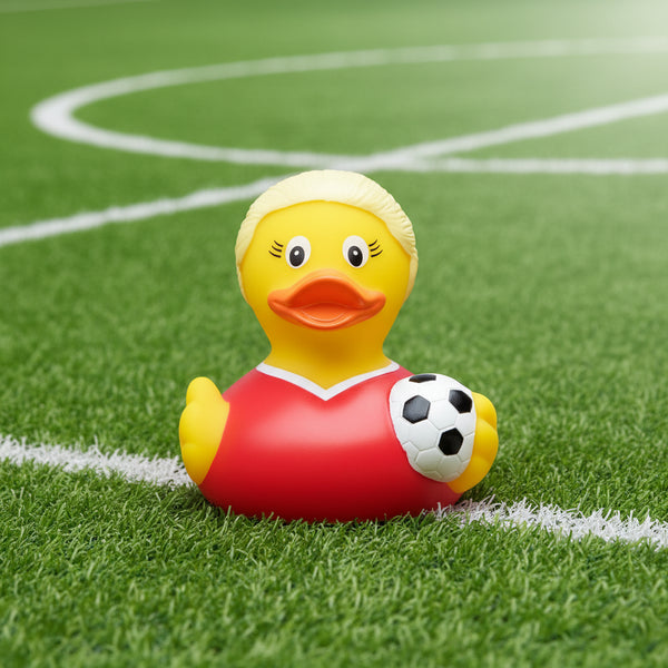 Gelbe quietscheente mit blonden haaren trägt rotes fußballtrikot und hält schwarz wei en fußball