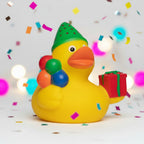 Gelbe quietsche-ente mit grünem wassermelonen-partyhut hält bunte luftballons und rotes geschenk zum geburtstag