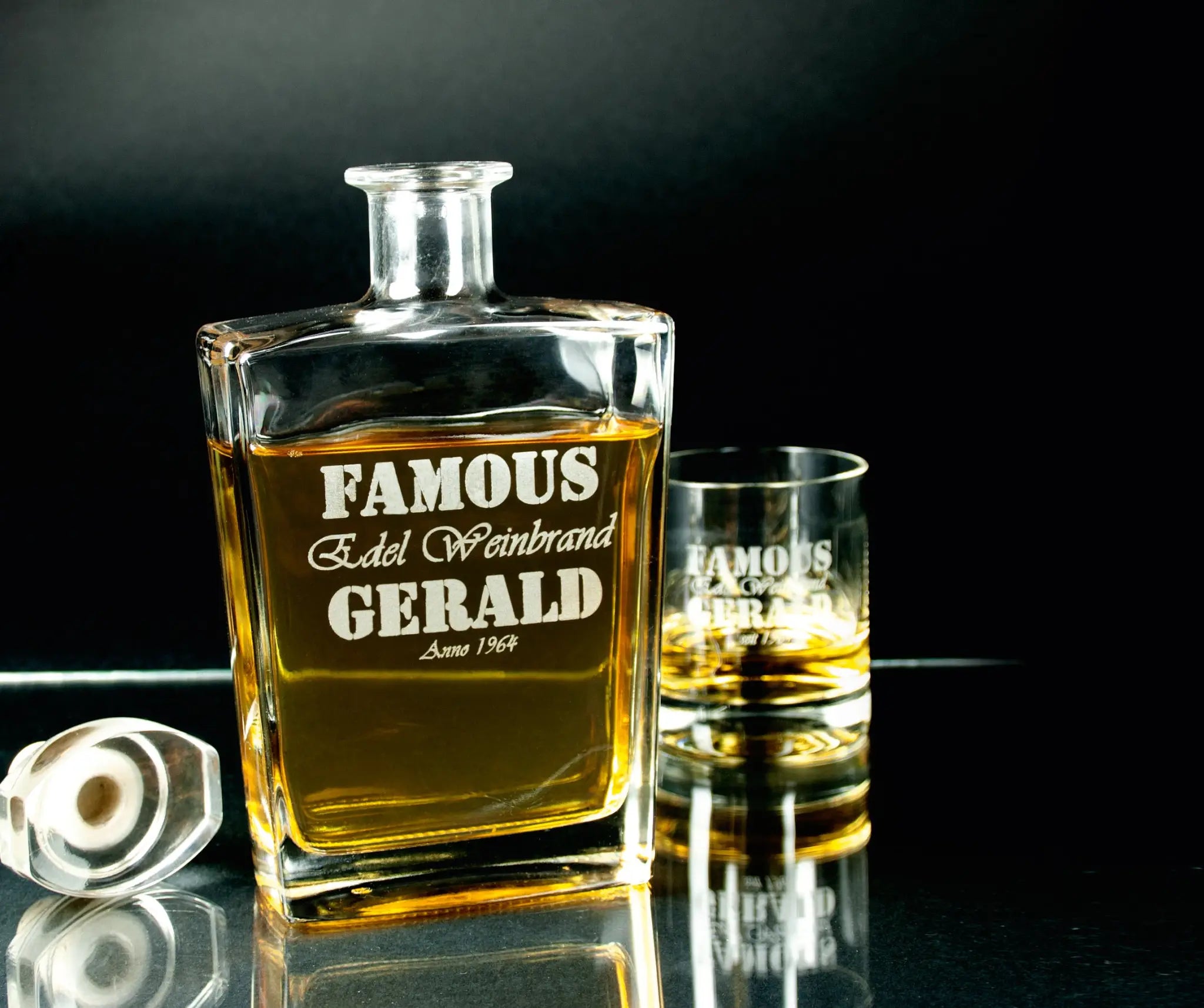 Klarer glas karaffe mit gravur famous edel weinbrand gerald seit 1964 gefüllt mit bernsteinfarbenem whiskey