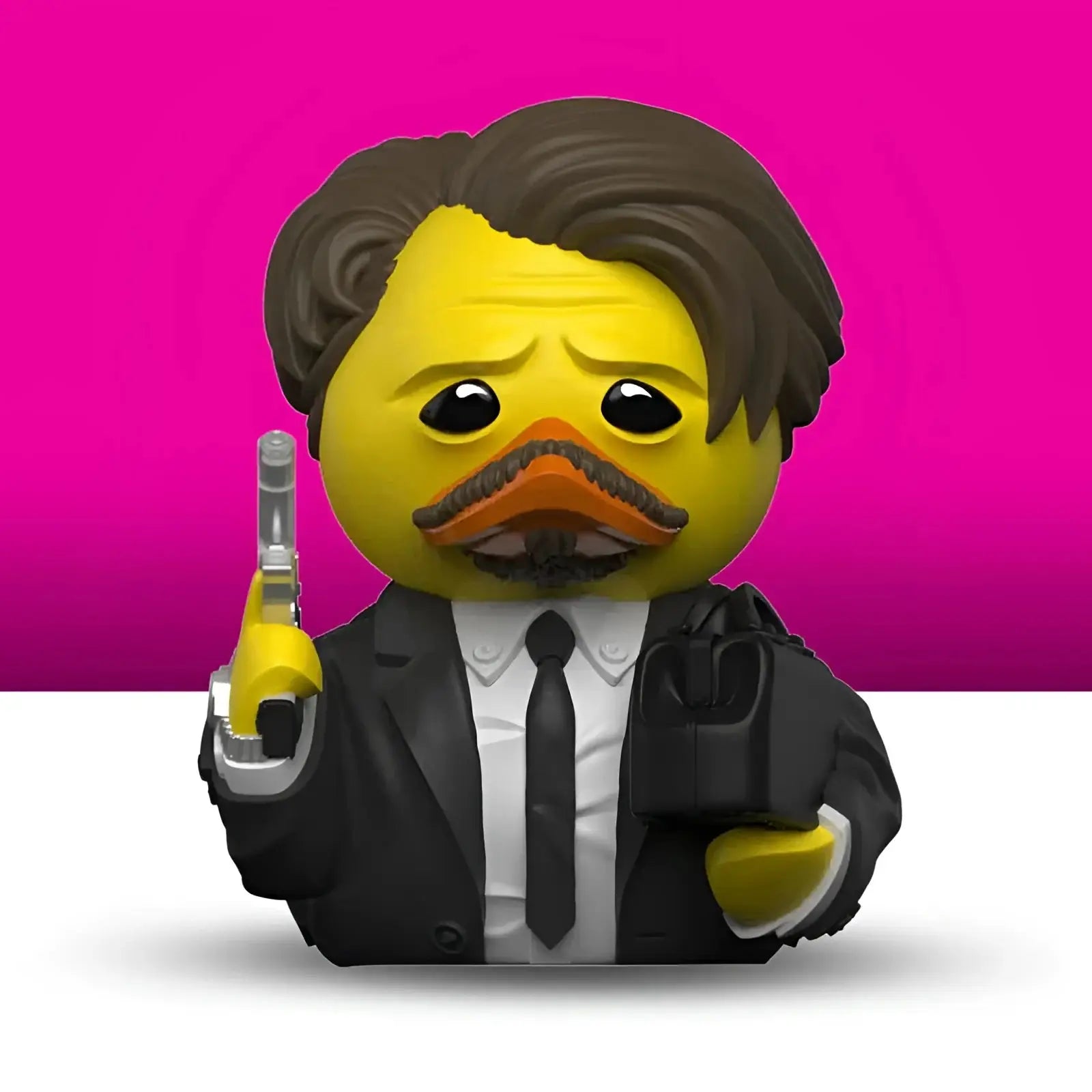Gelbe badeenten figur mit braunen haaren und schnurrbart in schwarzem anzug mit pistole aus geschenkset reservoir dogs