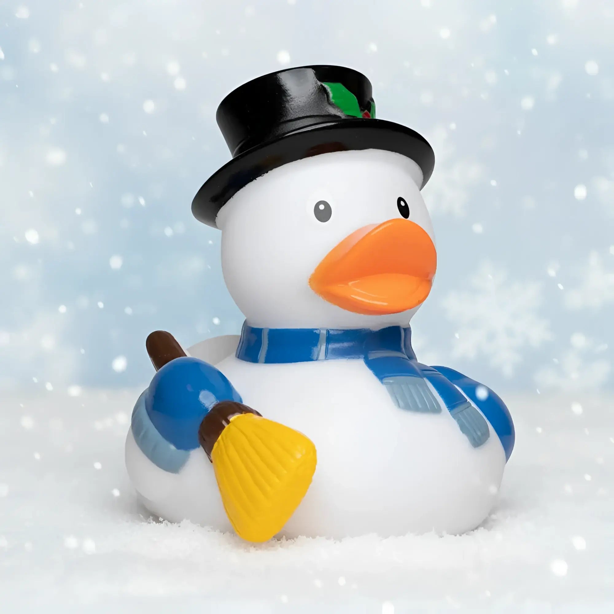Weiße quietsche-ente schneemann mit schwarzem zylinder, blau gestreiftem schal und gelbem pinselgriff