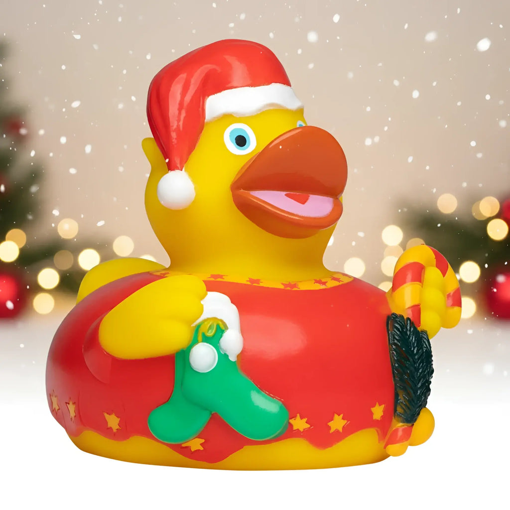 Gelbe quietsche-ente mit rotem weihnachtsmann-hut, grüner weihnachtsstrumpf und gestreiftem zuckerstock