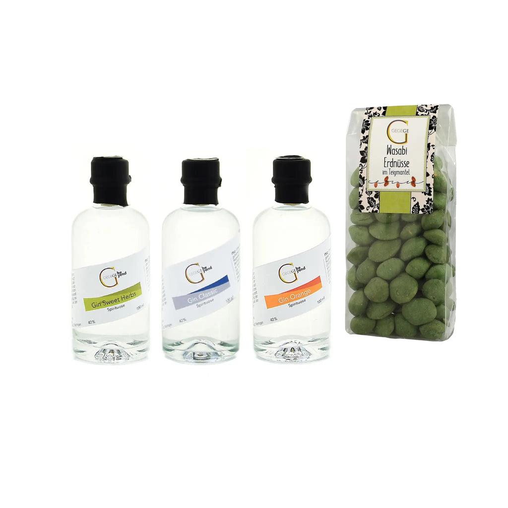 Drei klare glasflaschen mit schwarzen deckeln im gin tasting geschenkset mit sorten sweet herbs classic und orange