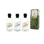 Drei klare glasflaschen mit schwarzen deckeln im gin tasting geschenkset mit sorten sweet herbs classic und orange