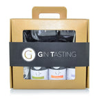 Gold strukturierte geschenkbox mit schwarzem band gin tasting mit drei kleinen flaschen und glas fürs probieren