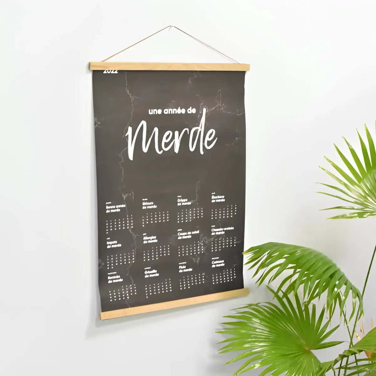 Hängender magnetrahmen aus holz mit schwarzem marmor muster und weißer schrift une année de merde, 51 cm groß