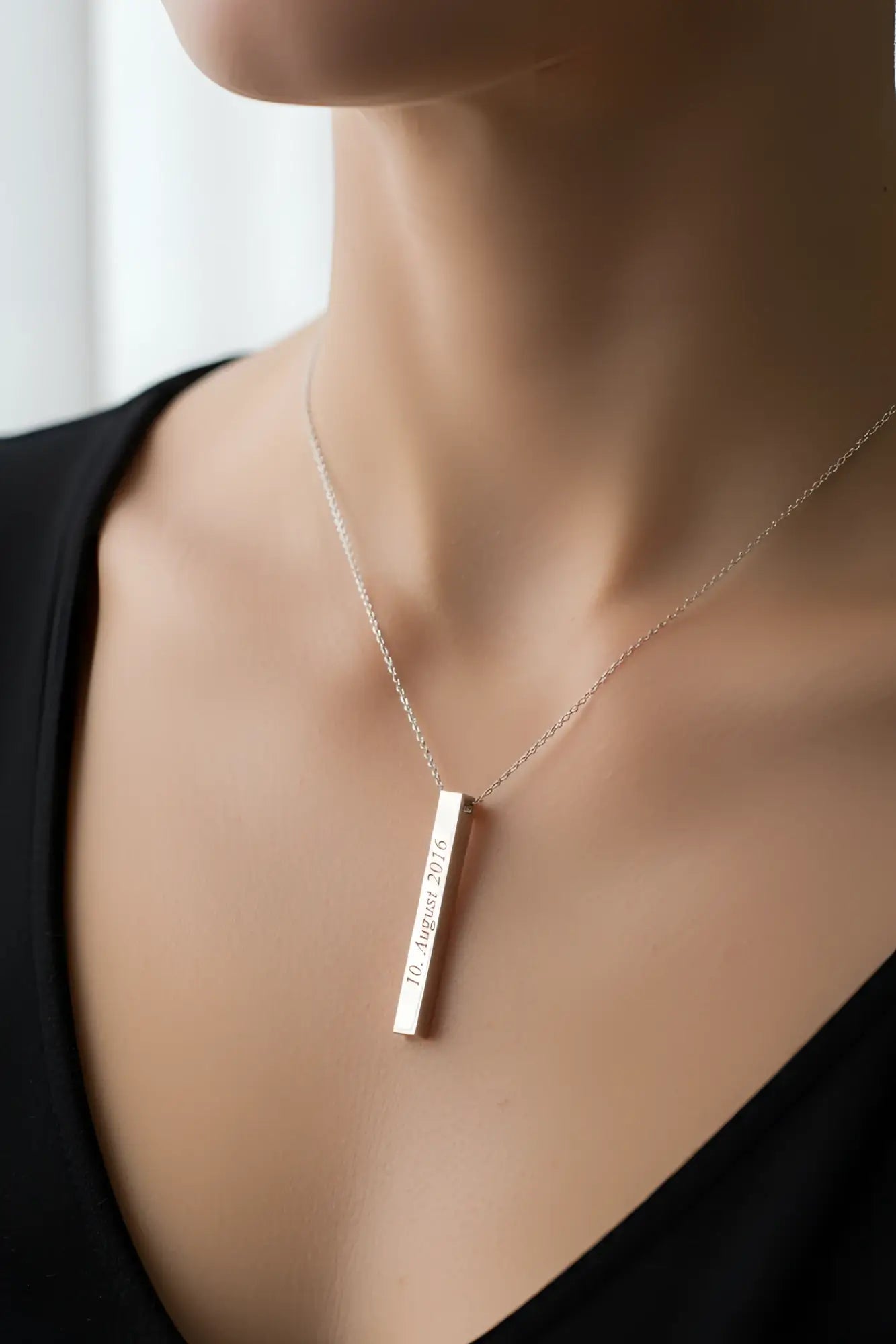Eine silberne halskette säule mit graviertem datum 10 und feiner kette als personalisiertes geschenk