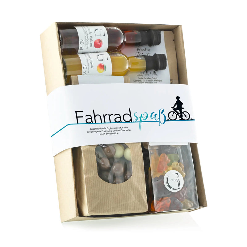Ein beige karton geschenkset fahrradspaß mit drei kleinen olivenölflaschen und schokolade sowie gummy candies