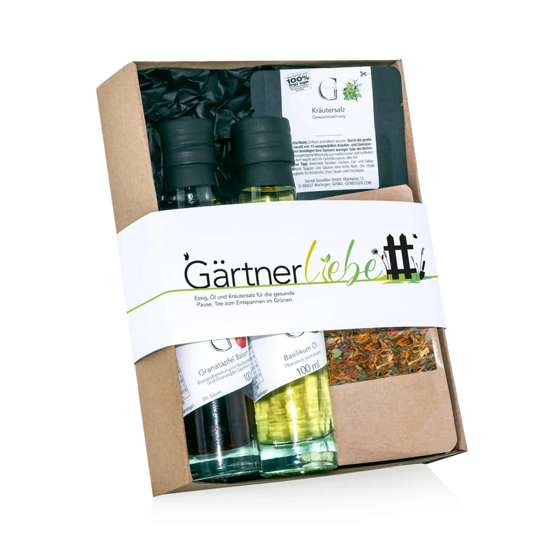 Braune papierschachtel mit hobby-set gärtnerliebe präsentiert mix aus kräuterölen und salz in glasflaschen mit schwarzen deckeln