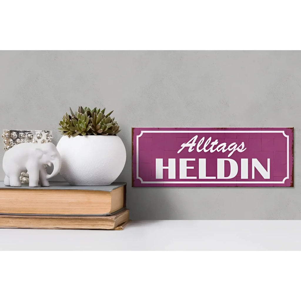 Lila holzschild mit weißer schrift alltags heldin als dekoratives geschenk 27x10cm vor strukturiertem hintergrund