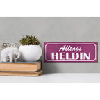 Lila holzschild mit weißer schrift alltags heldin als dekoratives geschenk 27x10cm vor strukturiertem hintergrund