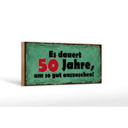Ein rustikales grünes holzschild 27x10 cm mit verzierter schwarzer bordüre und rotem schwarzen deutschen spruch