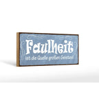 Blaues holzschild mit weißer dekorativer schrift und dunklem rahmen spruch faulheit quelle großen geistes