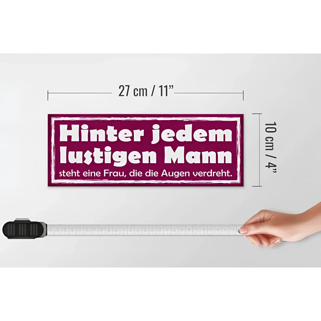 Rechteckiges maroon holzschild spruch 27x10cm mit weißem text hinter jedem lustigen mann steht eine frau die die augen verdreht