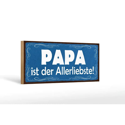 Blaues rechteckiges holzschild mit weißem text papa ist der allerliebste und dekorativen wirbeln am rand