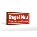 Rotes rechteckiges holzschild mit weißem text regel nr 1 finger weg vom werkzeug 27x10 cm