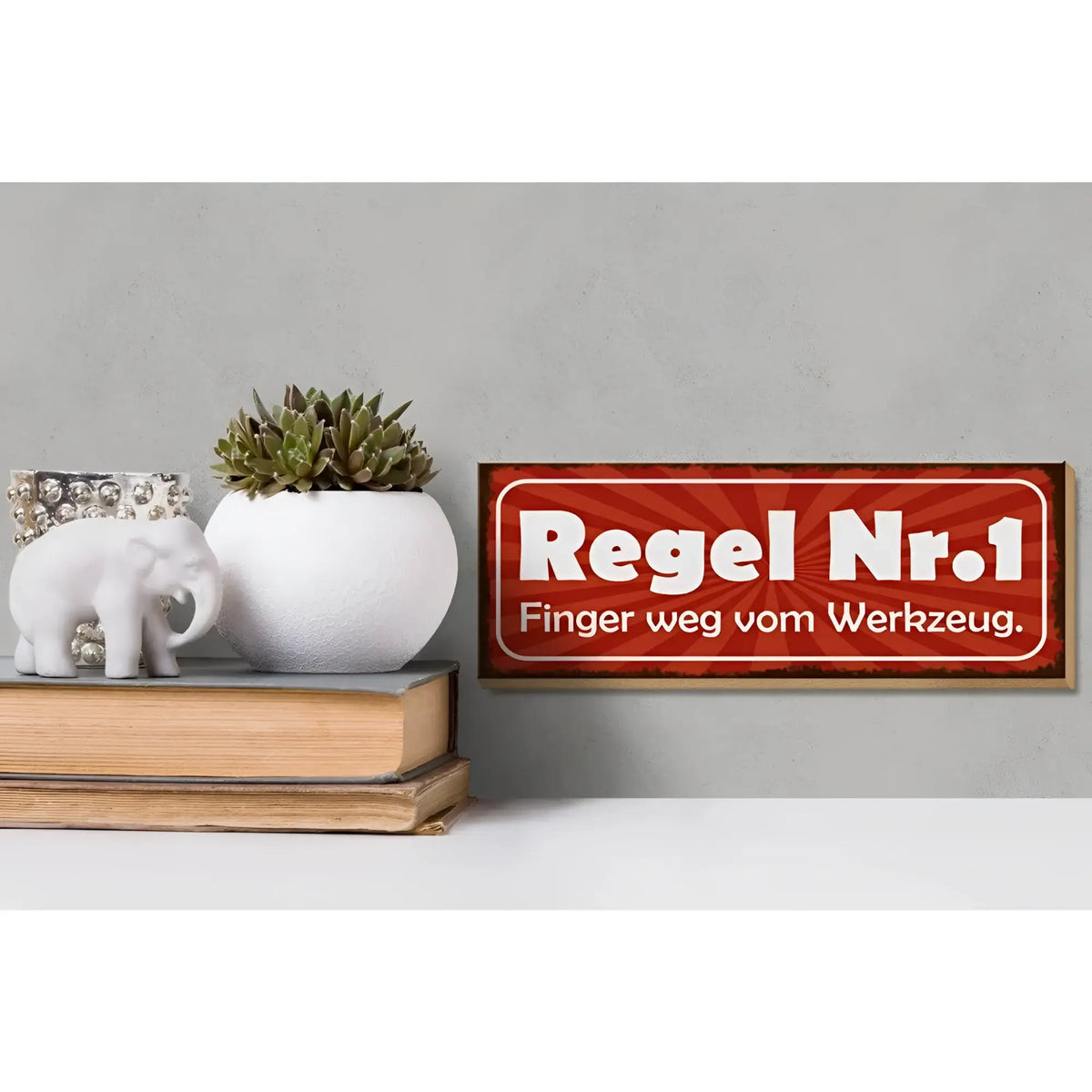 Rotes holzschild 27x10cm mit weißem text regel nr 1 finger weg vom werkzeug und sonnenstrahlenmuster