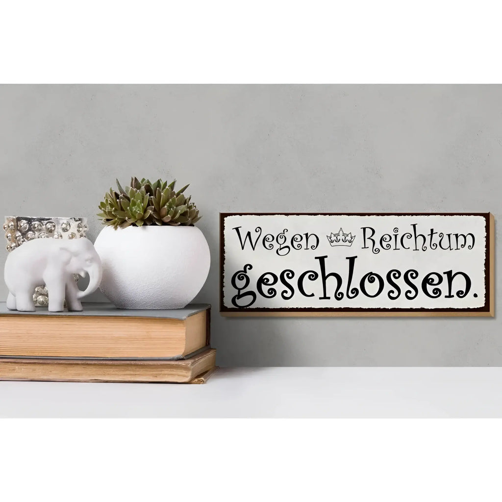 Weißes keramikwandschild mit schwarzem kursivtext wegen reichtum geschlossen und kleiner krone in holzrahmen