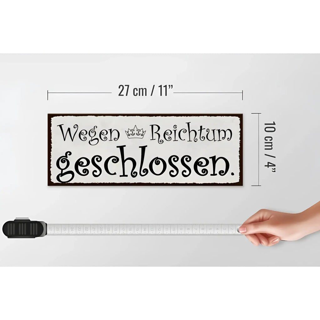 Ein rechteckiges holzschild mit dunkelbrauem rahmen und schwarzer schrift wegen reichtum geschlossen zur dekoration