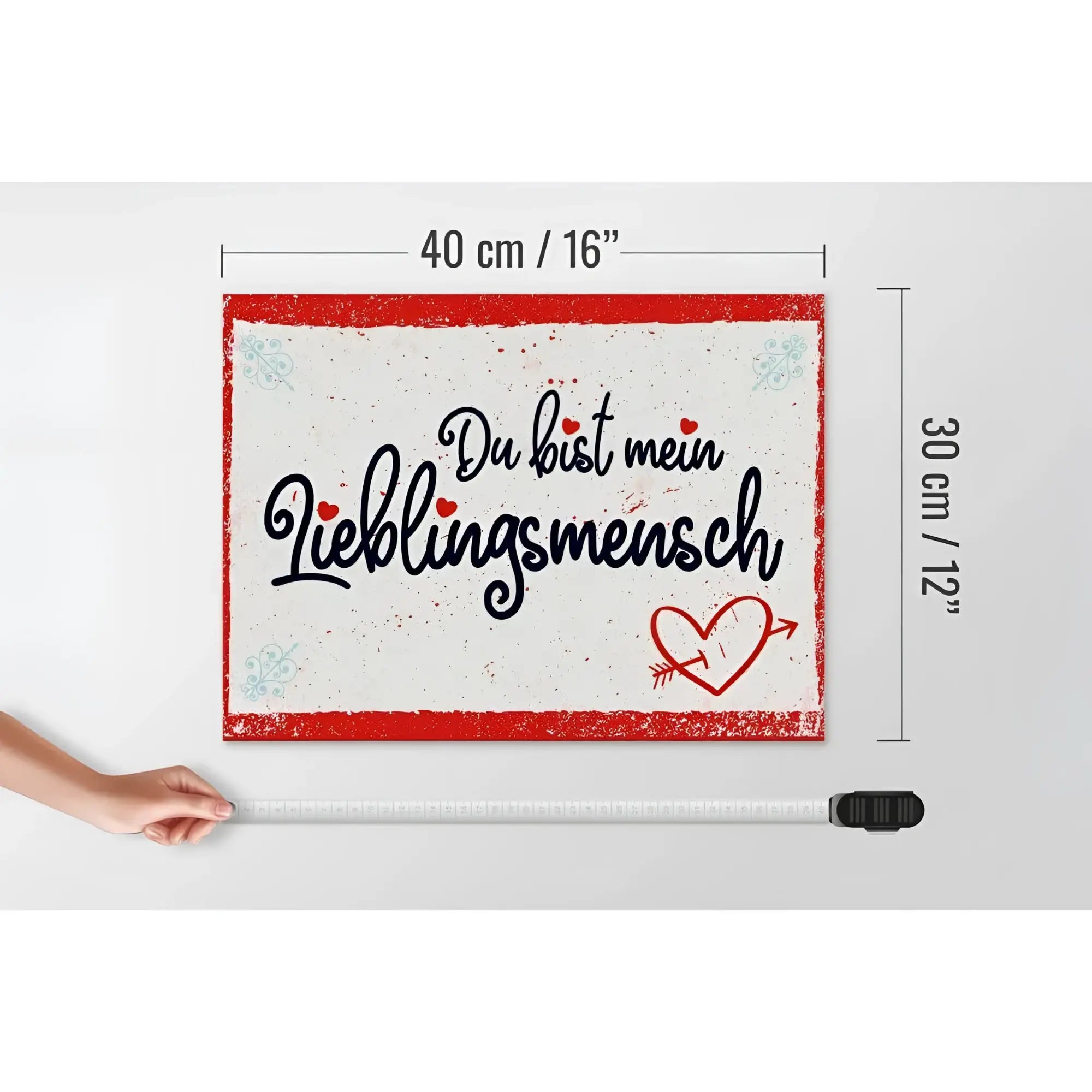 Ein rechteckiges weißes holzschild 30x40cm mit rotem rahmen, schwarzem kursivtext du bist mein lieblingsmensch und rotem herz mit pfeil