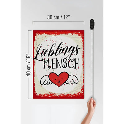 Red gerahmtes holzschild mit weißem vintage hintergrund und schwarzem lieblingsmensch schriftzug über rotem herz mit flügeln