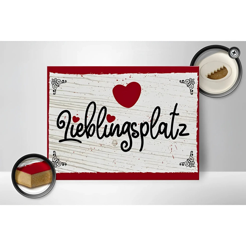 Rotes und weißes holzschild 30x40cm mit schwarzem schriftzug lieblingsplatz und rotem herz oben drauf