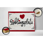 Rotes und weißes holzschild 30x40cm mit schwarzem schriftzug lieblingsplatz und rotem herz oben drauf