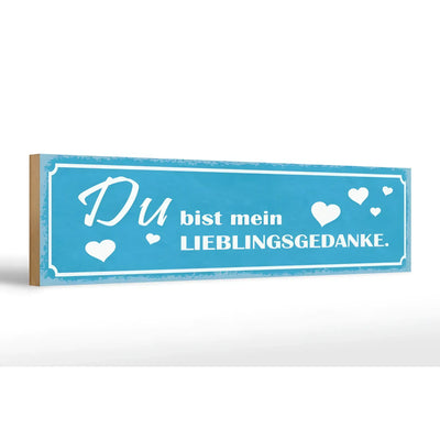 Blaues rechteckiges hölzernes schild mit weißem schriftzug du bist mein lieblingsgedanke und herzmotiven zur deko