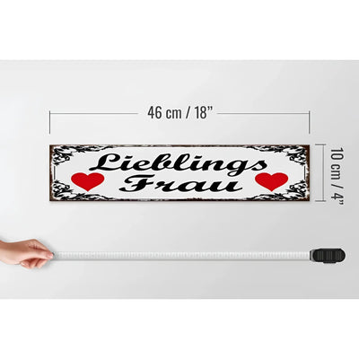 Weißes holzschild 46x10cm mit schwarzem cursivtext lieblingsfrau, roten herzen und dekorativem rahmen als geschenk