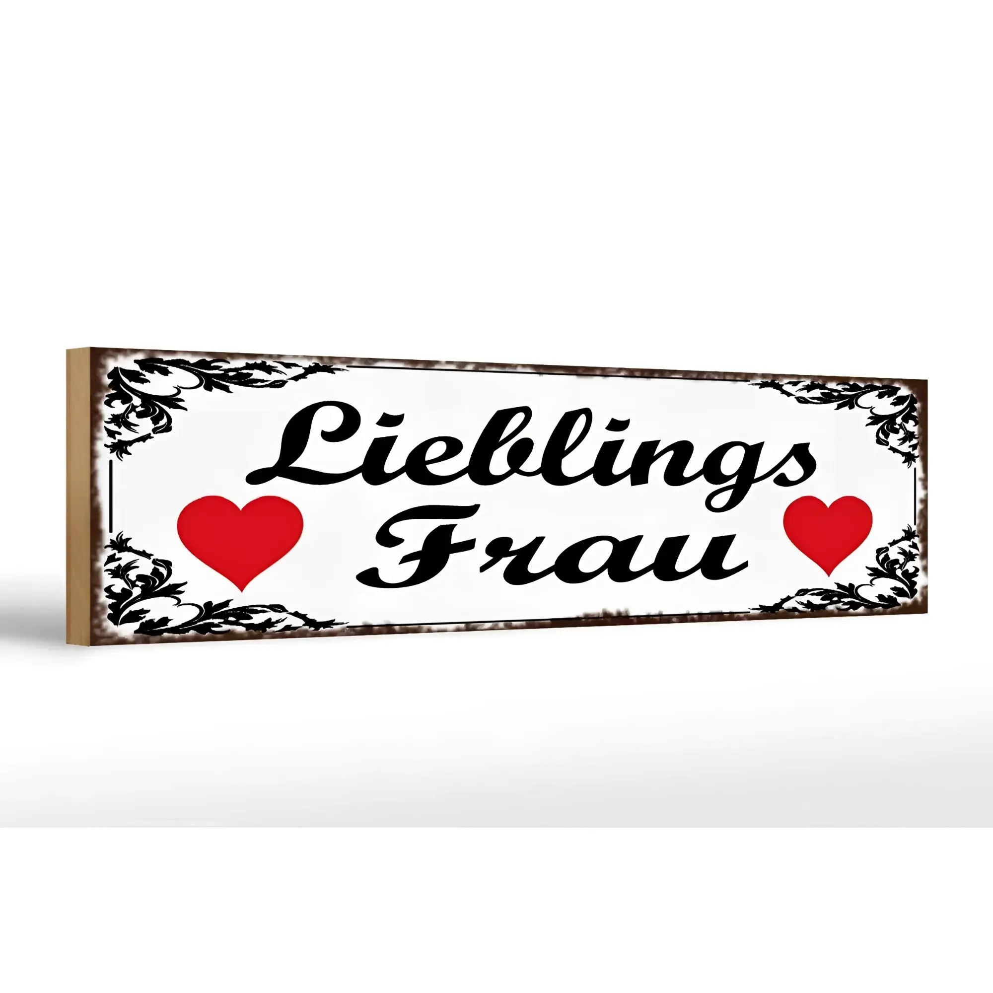 Weißes rechteckiges Holzschild mit schwarzem Ornamentrahmen und dem Schriftzug lieblingsfrau zwischen roten Herzen, 46x10cm