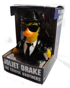 Ein schwarzer gummiente im stil eines detektivs mit fedora hut, sonnenbrille und anzug namens joliet drake von celebriducks