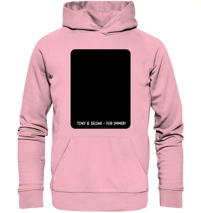 Ein weiches pinkes kinderhoodie mit schwarzem rechteckigem patch und weißem text aus der statement-collection