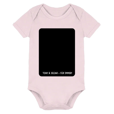 Pale pink baby onesie with black rectangular panel and white text tony & selina für immer aus der statement collection